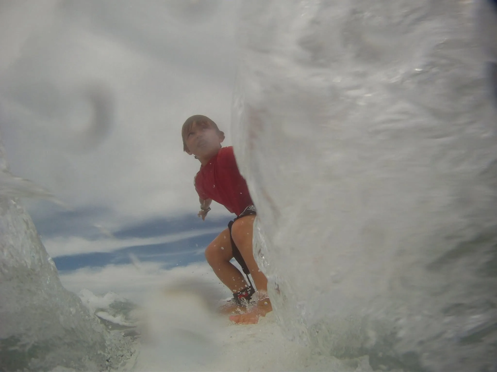 A young Nicolas surfing inside a breaking wave